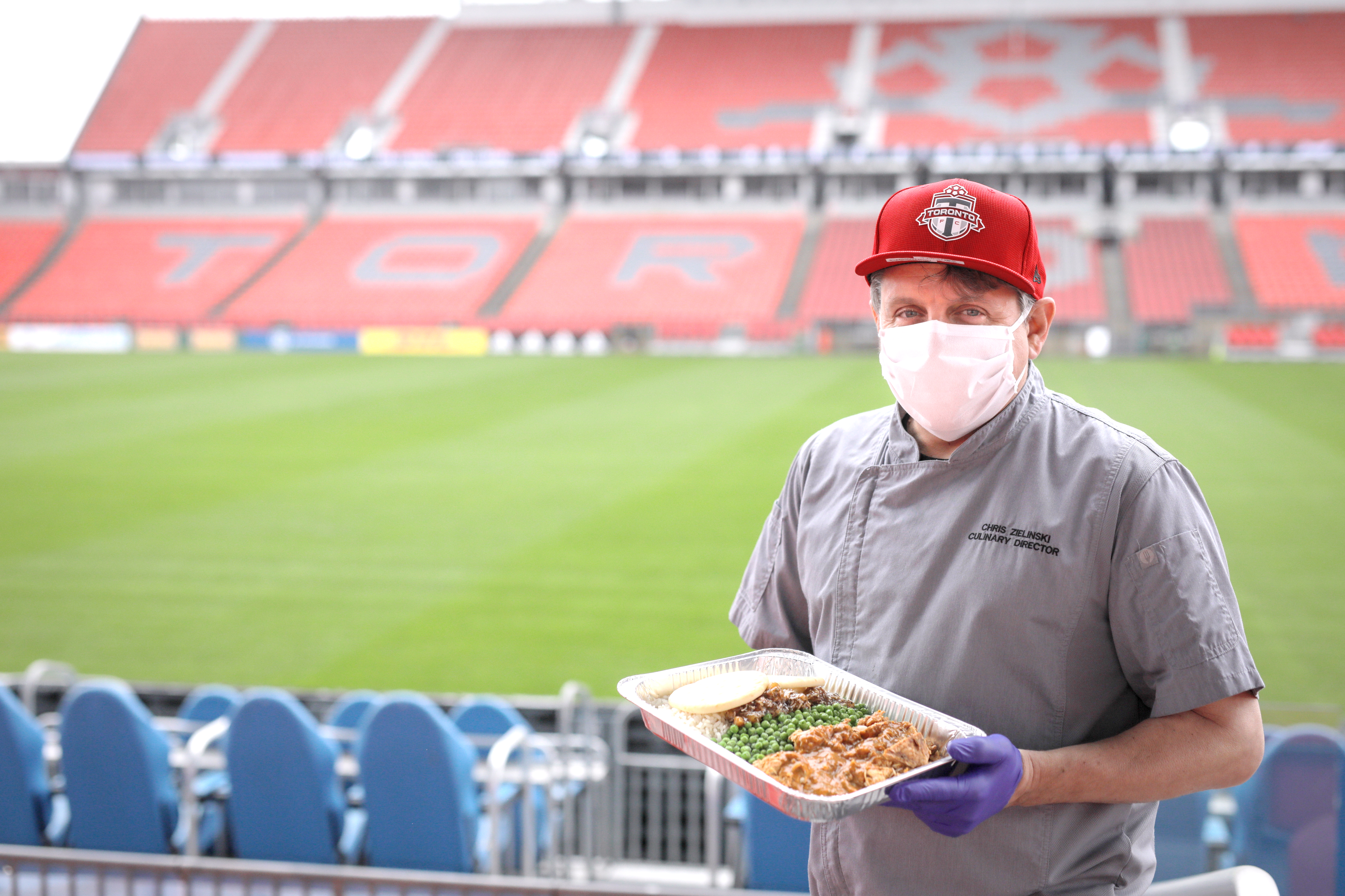 A volunteer holds a hot meal at BMO fields.